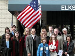 A group of people with a person in the center holding a US flag